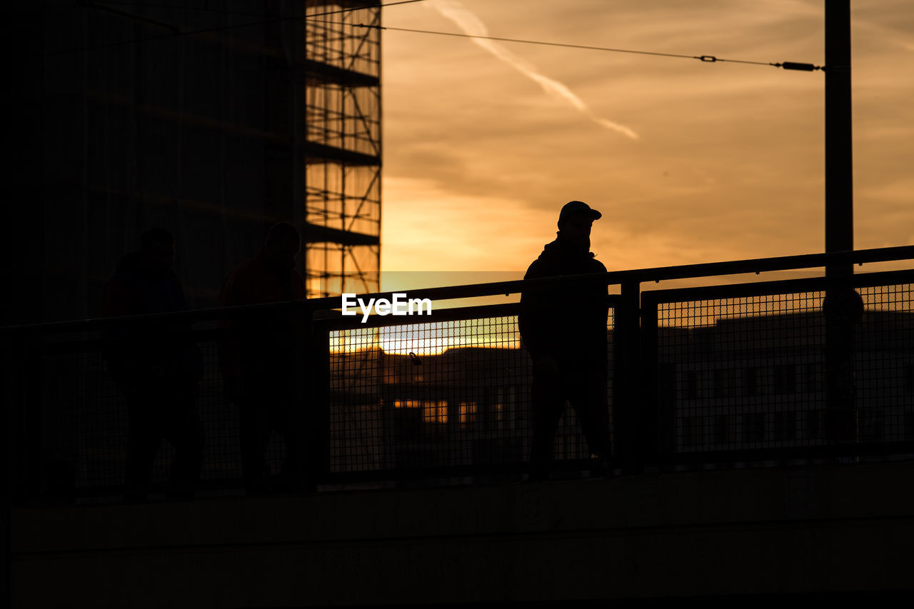 SILHOUETTE MAN STANDING AGAINST SKY AT SUNSET