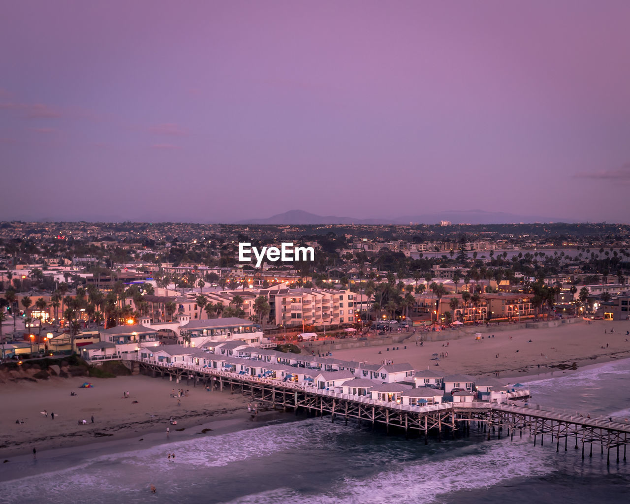 Drone view of crystal pier cottages hotel. san diego california sunset with city lights.