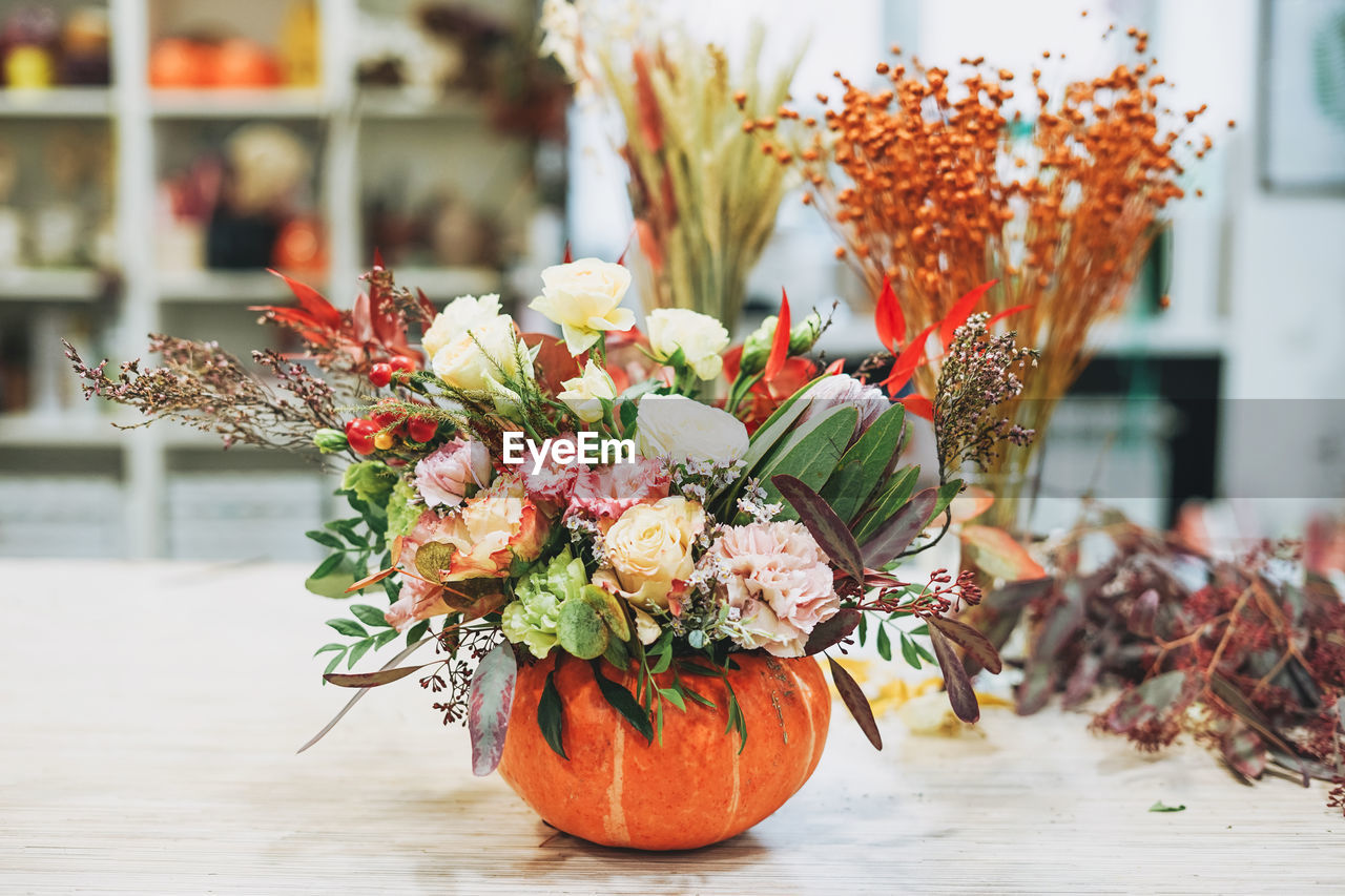 Diy autumn flower arrangement bouquet in pumpkin at floristry studio