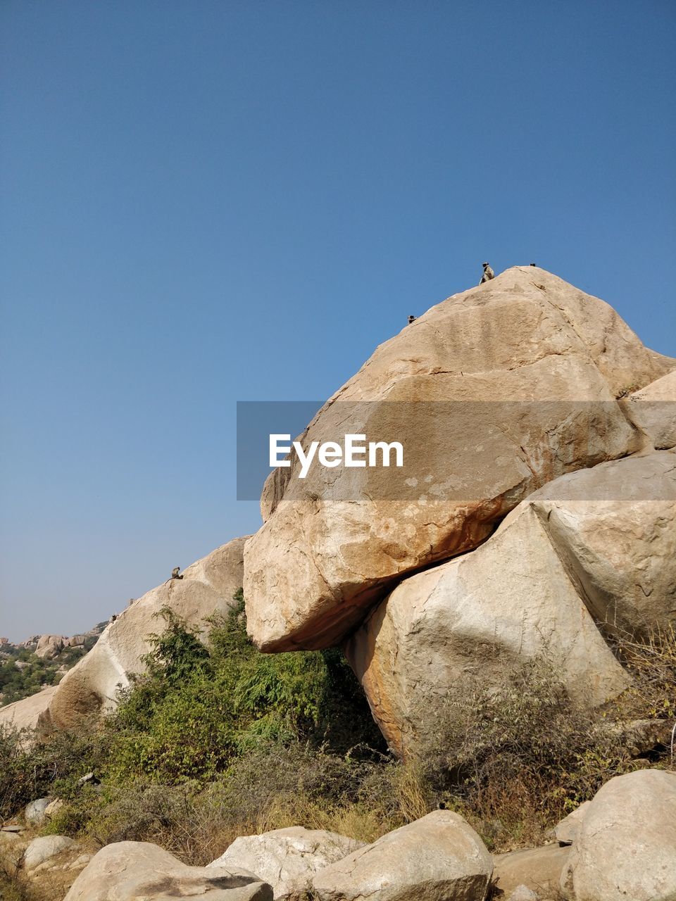 LOW ANGLE VIEW OF ROCKS AGAINST CLEAR BLUE SKY