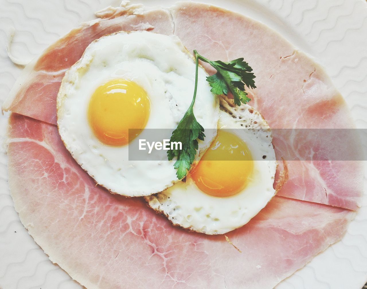 High angle view of fried egg on ham