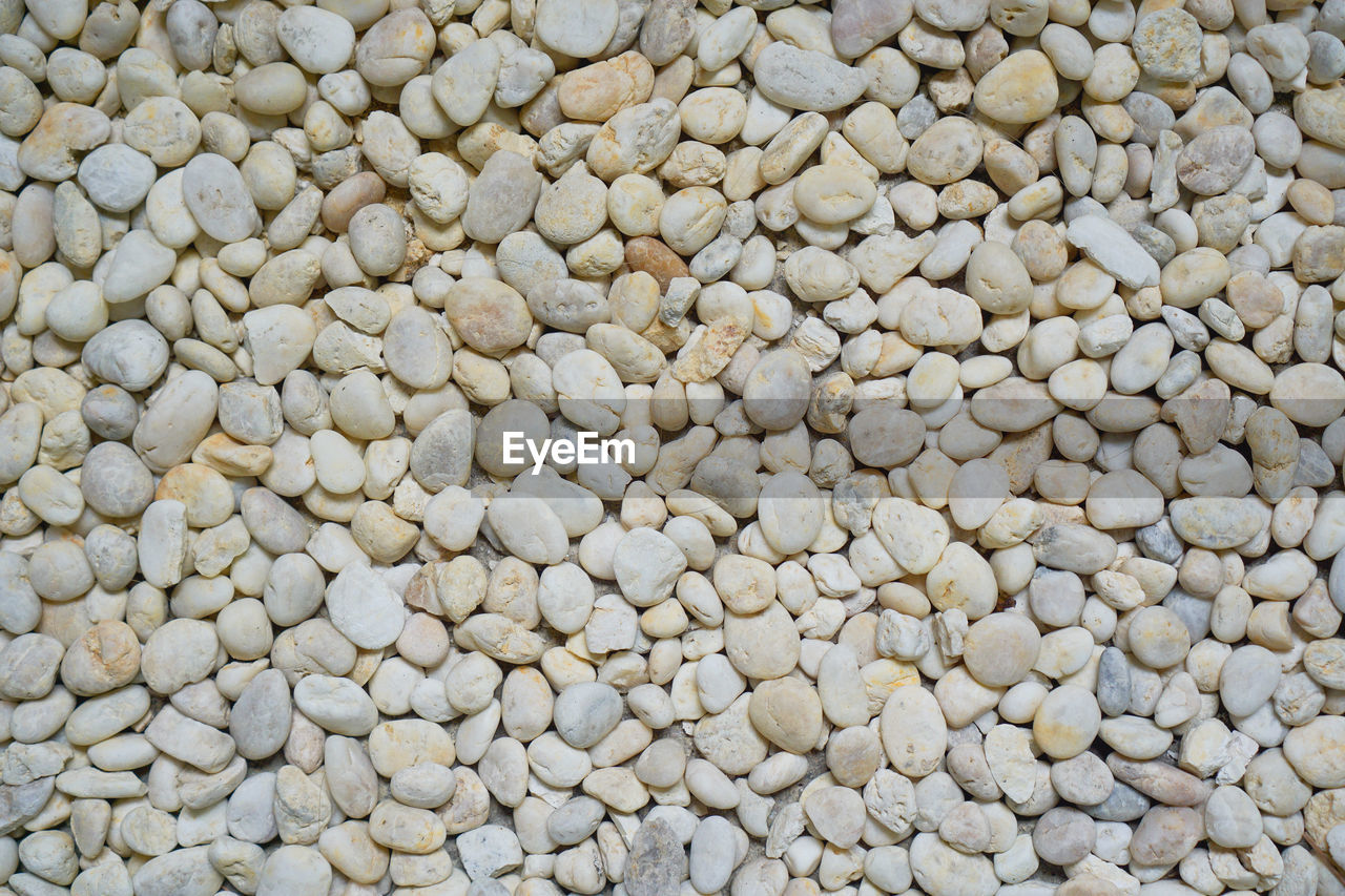HIGH ANGLE VIEW OF PEBBLES ON STONES