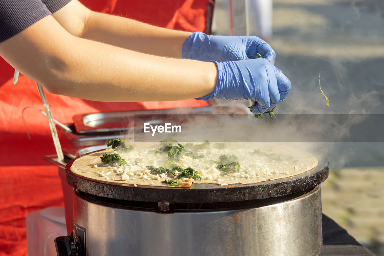 Demonstration cooking, chef making pancakes at naplavka street food market.