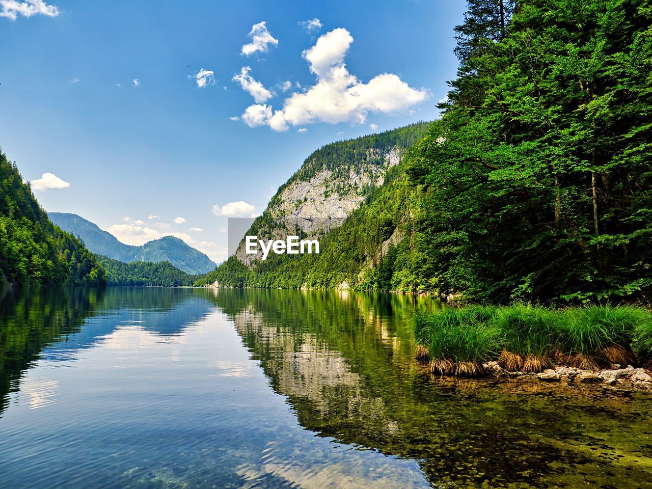 scenic view of lake by mountains against sky