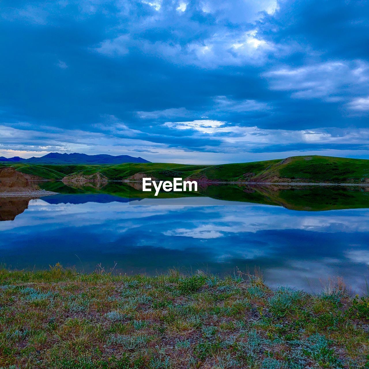 SCENIC VIEW OF LAKE AGAINST CLOUDY SKY