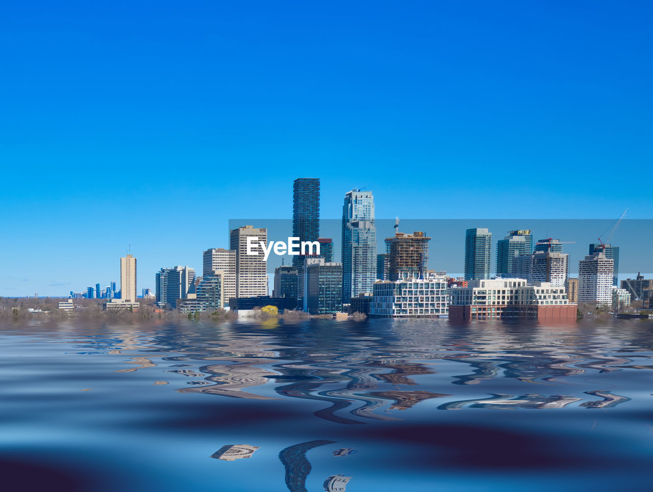 SEA BY BUILDINGS AGAINST CLEAR BLUE SKY
