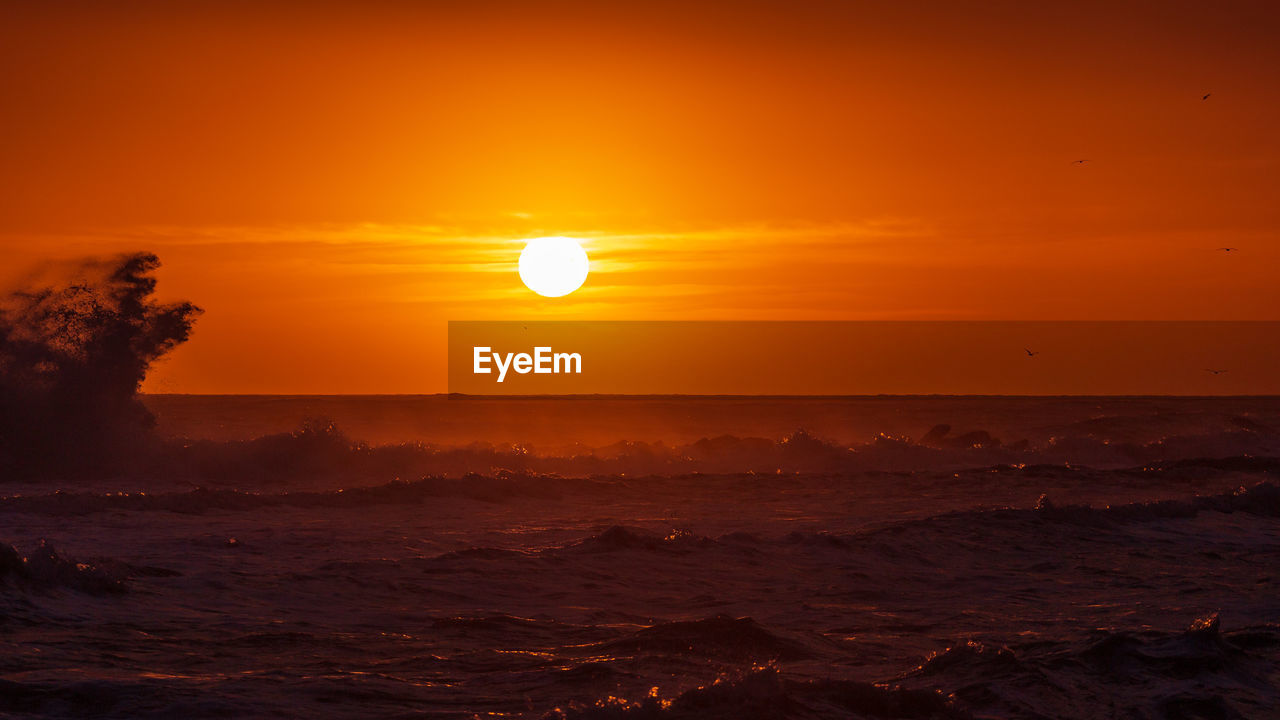 SCENIC VIEW OF SEA AGAINST ORANGE SKY