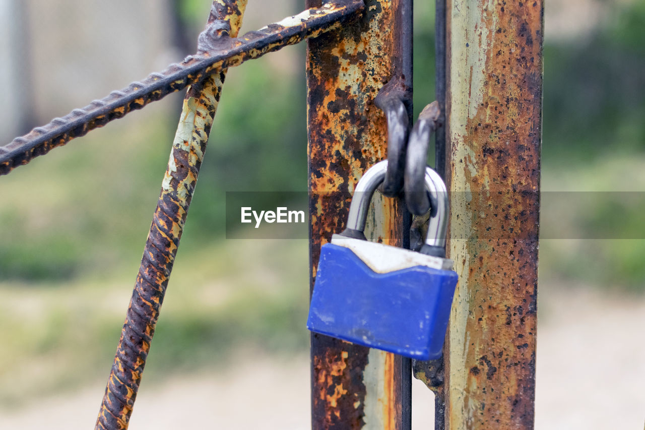 CLOSE-UP OF RUSTY CHAIN HANGING ON FENCE