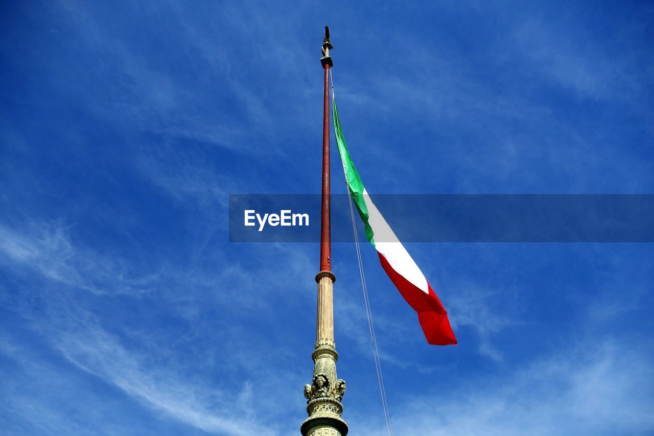 Low angle view of flag against blue sky