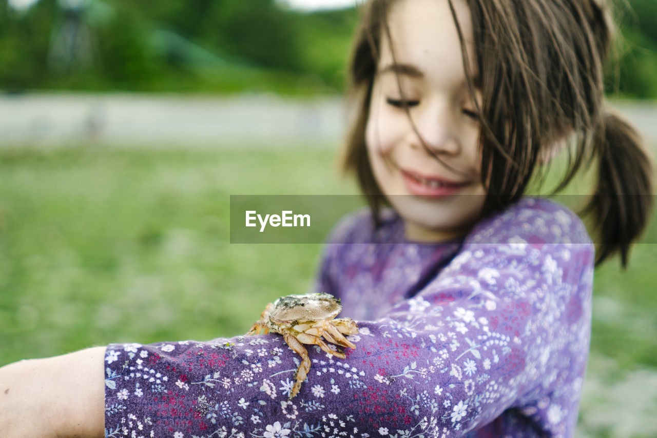 Closeup image of a shore crab on a child's arm