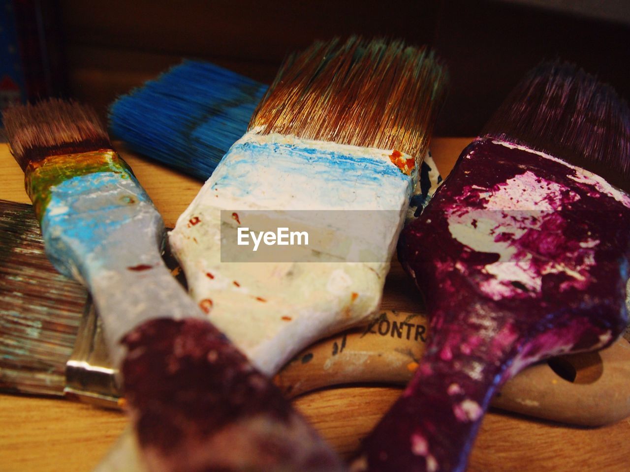 CLOSE-UP OF PAINTBRUSHES ON MULTI COLORED KITCHEN