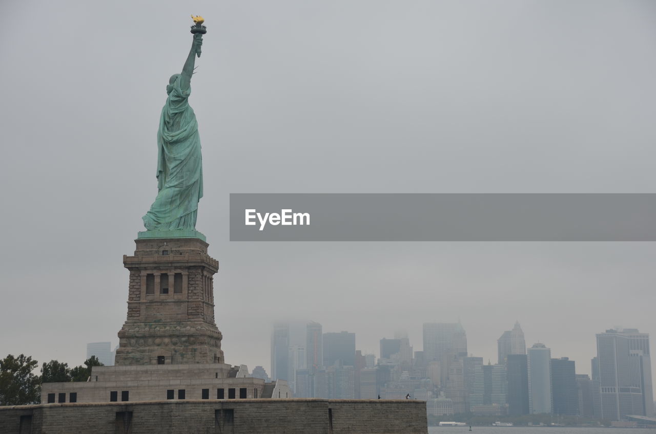 Statue of liberty against sky in city