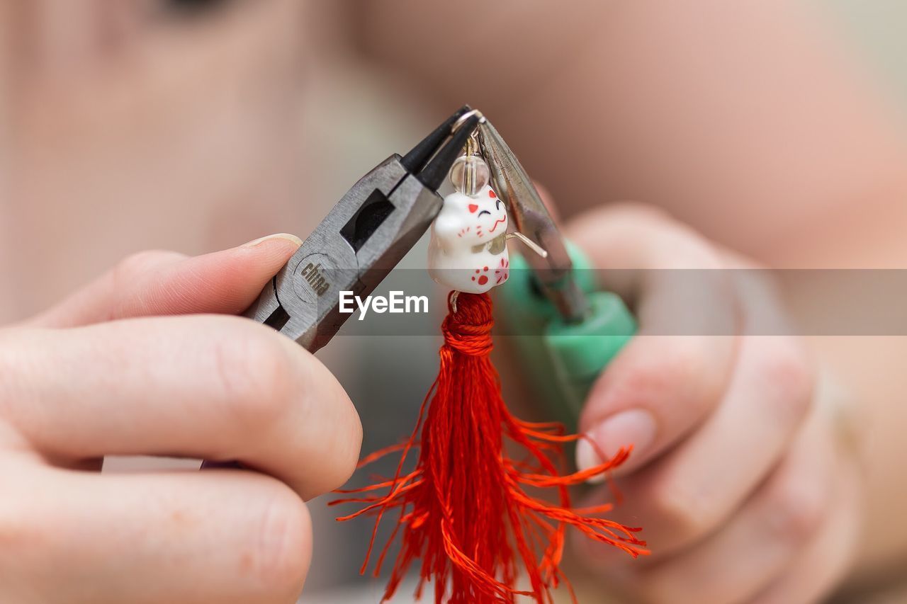 Cropped hands of person making decoration with tools