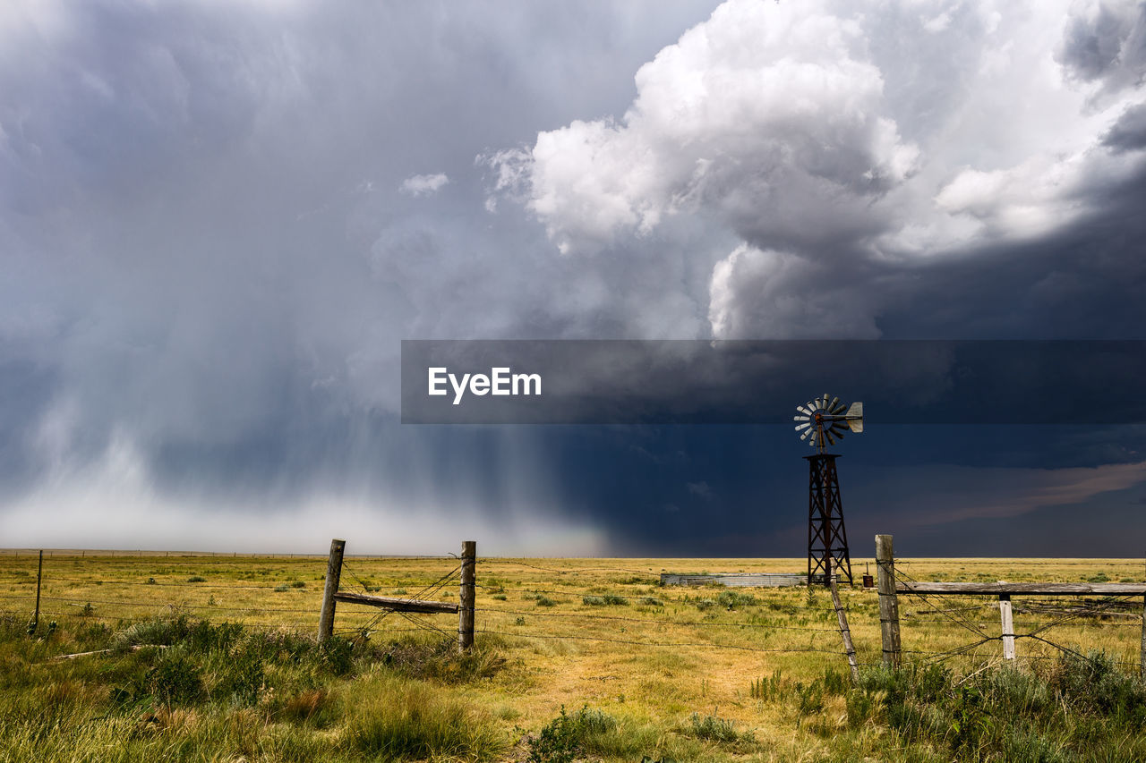 Scenic view of agricultural field against storm clouds