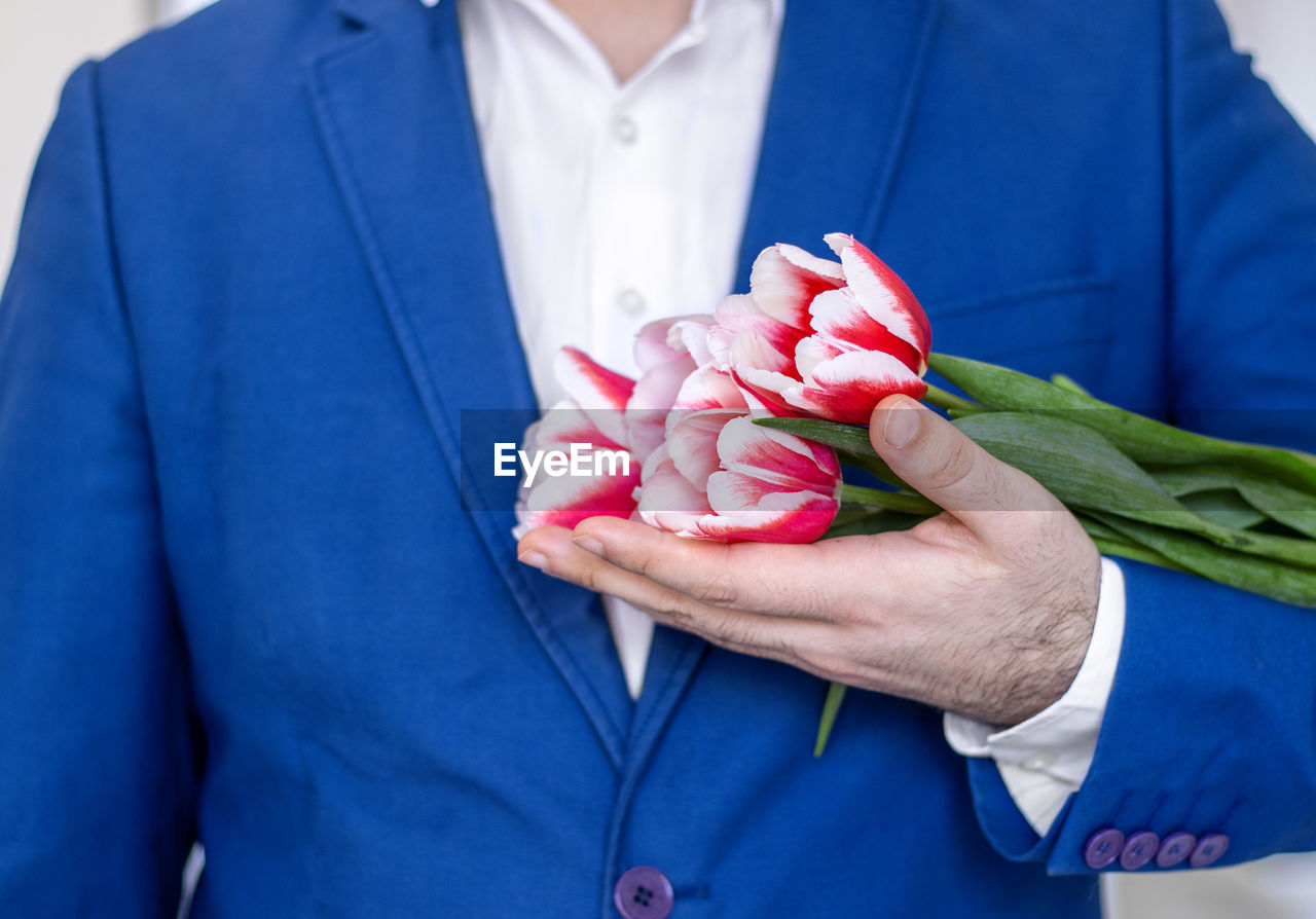 adult, holding, midsection, flower, blue, flowering plant, women, one person, hand, men, clothing, plant, rose, close-up, front view, person, love, positive emotion, emotion, standing, business, female, nature, freshness, bouquet, indoors