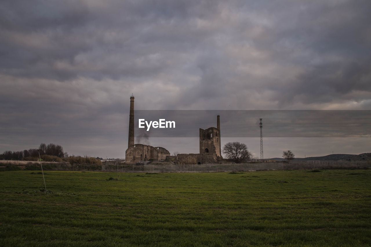 BUILT STRUCTURE AGAINST STORM CLOUDS IN SKY