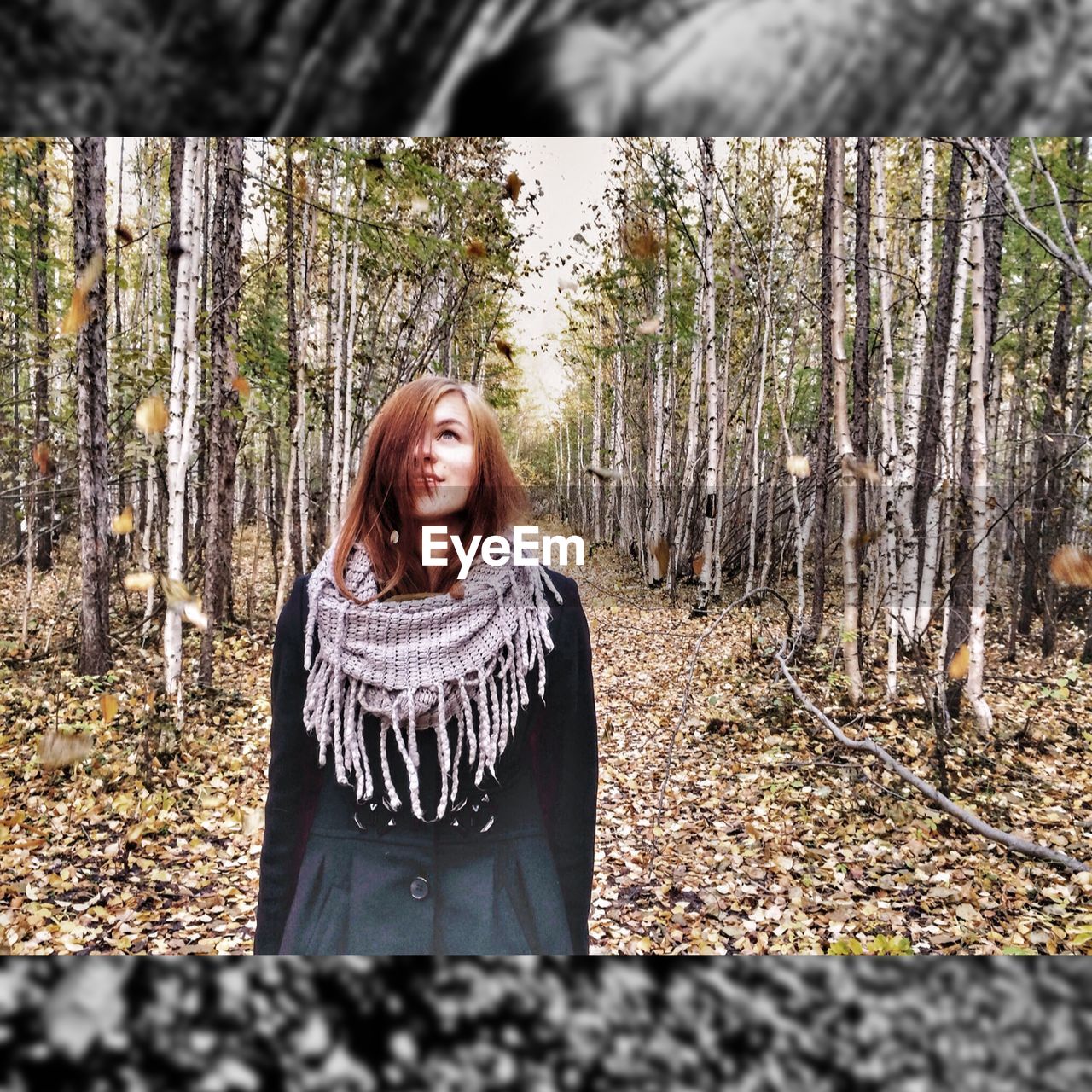 PORTRAIT OF SMILING YOUNG WOMAN IN FOREST