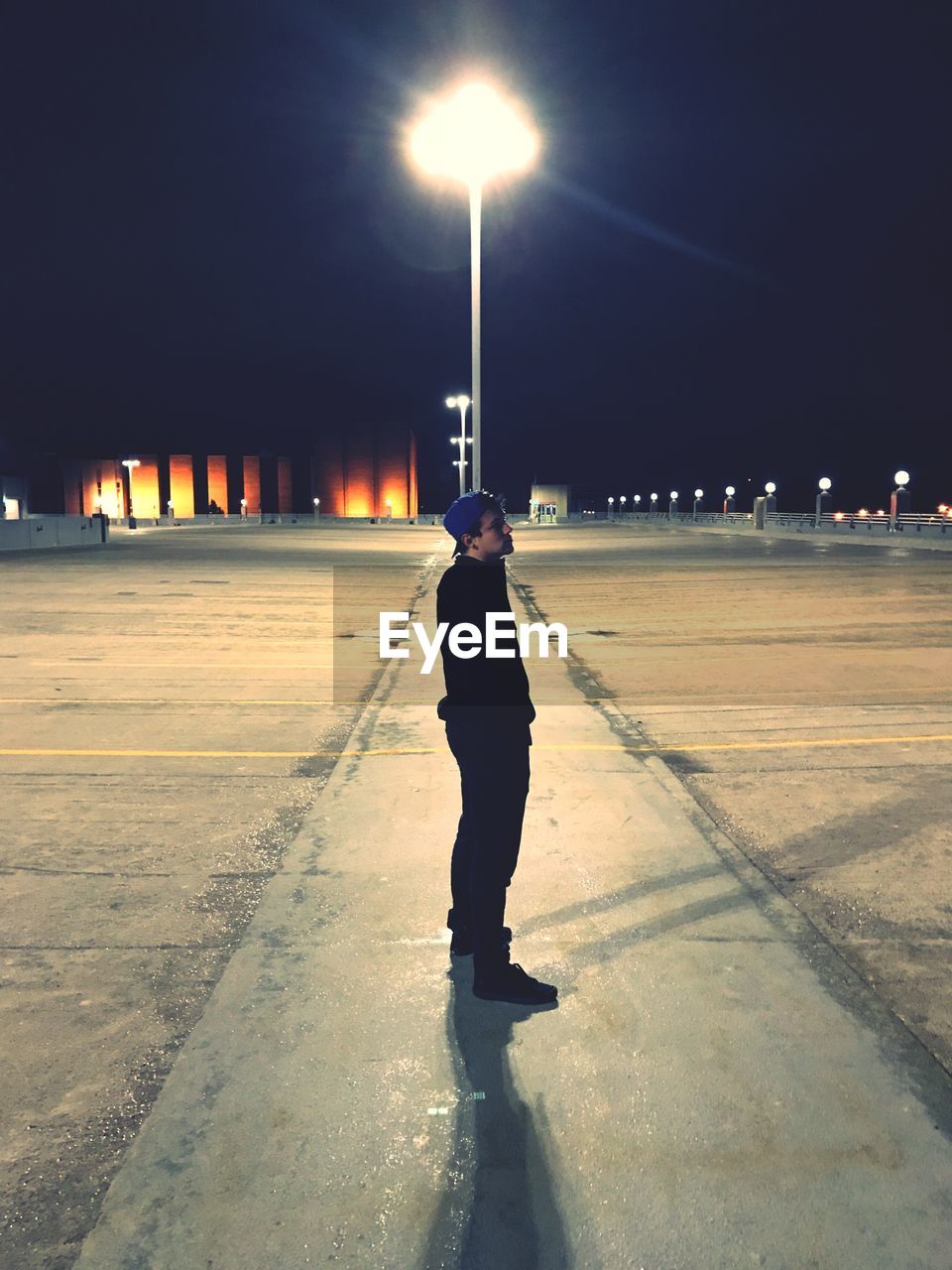 Full length of man standing on illuminated road during winter