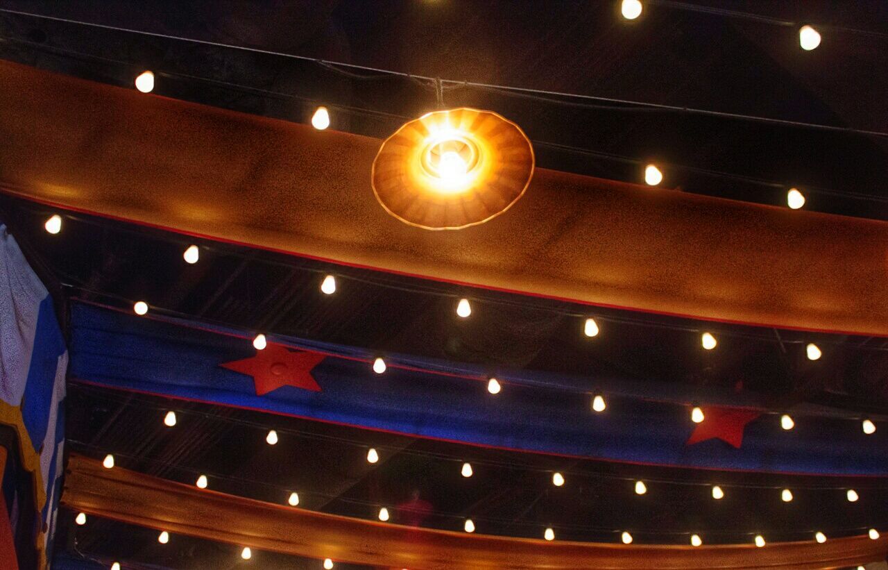 LOW ANGLE VIEW OF ILLUMINATED LIGHTS HANGING ON CEILING