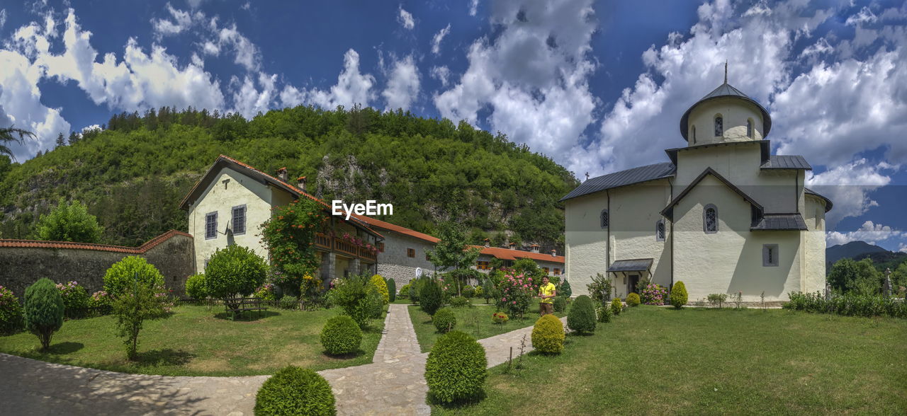 PANORAMIC VIEW OF TREES AND HOUSES AGAINST SKY