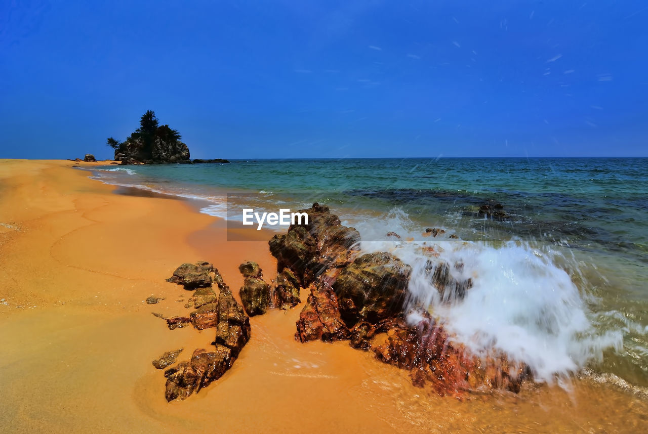 Scenic view of beach against blue sky