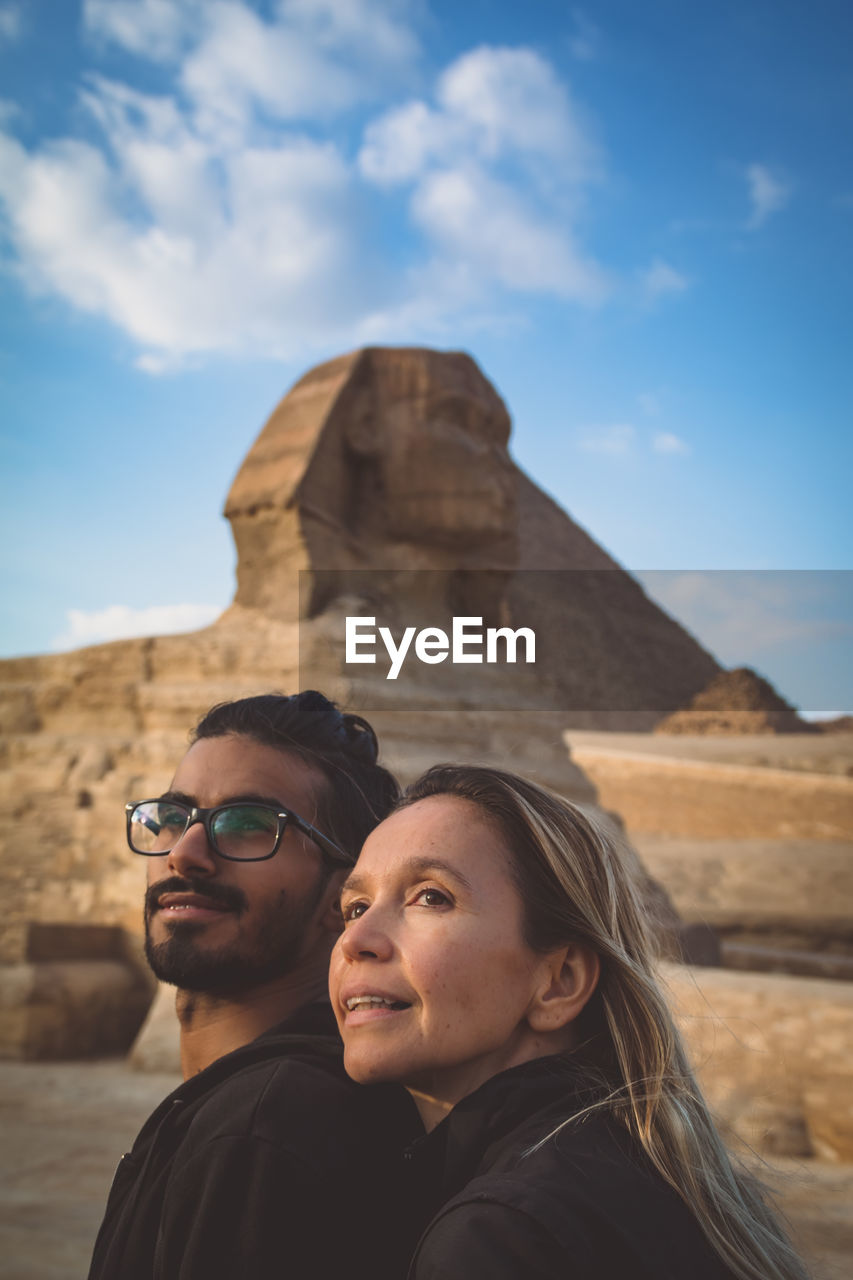 Couple looking away against the sphinx and sky