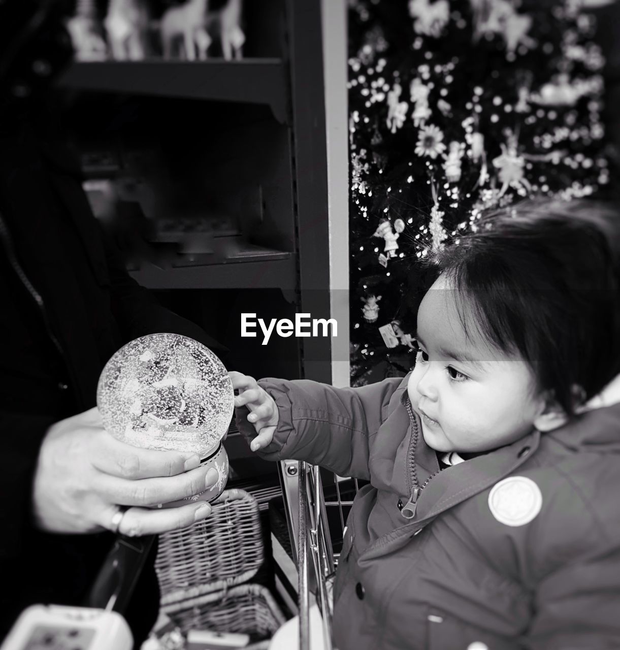 Cute baby girl looking at toy in store