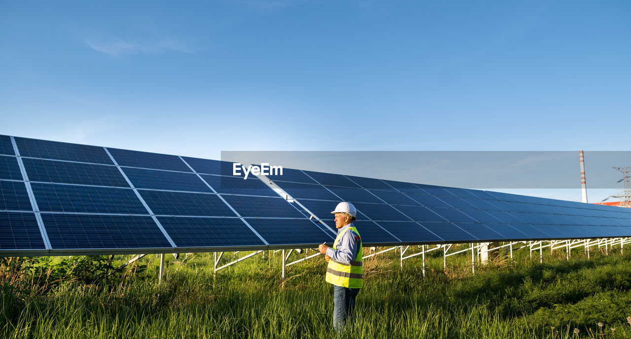 Solar engineer working with digital tablet at renewable energy farm