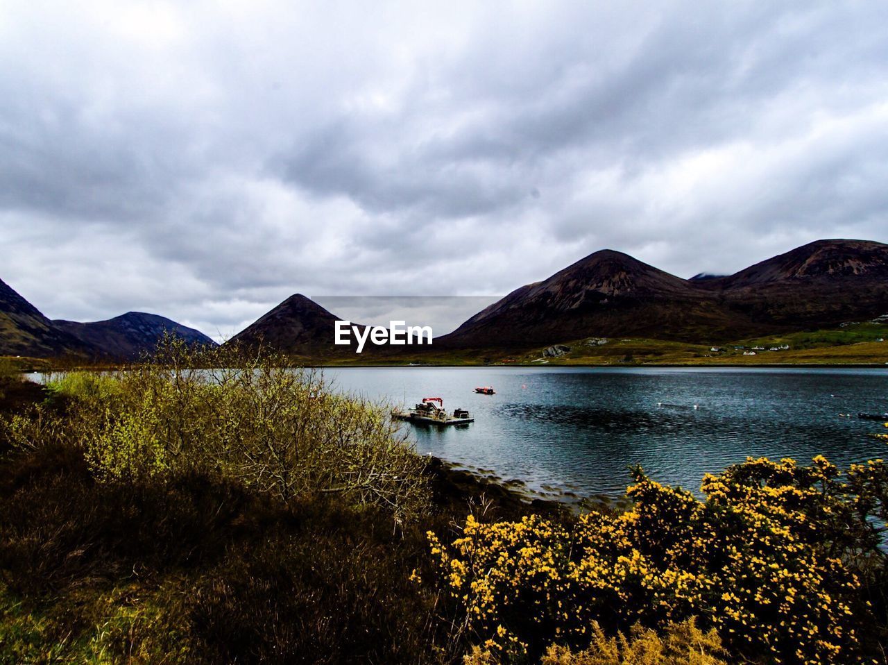 Scenic view of lake against cloudy sky