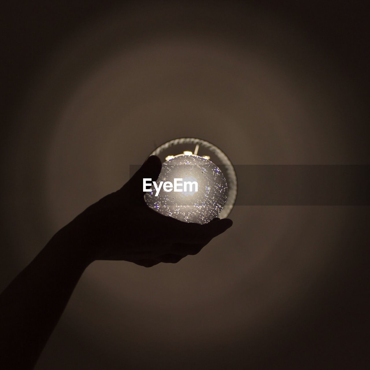Close-up of persons hand holding crystal ball