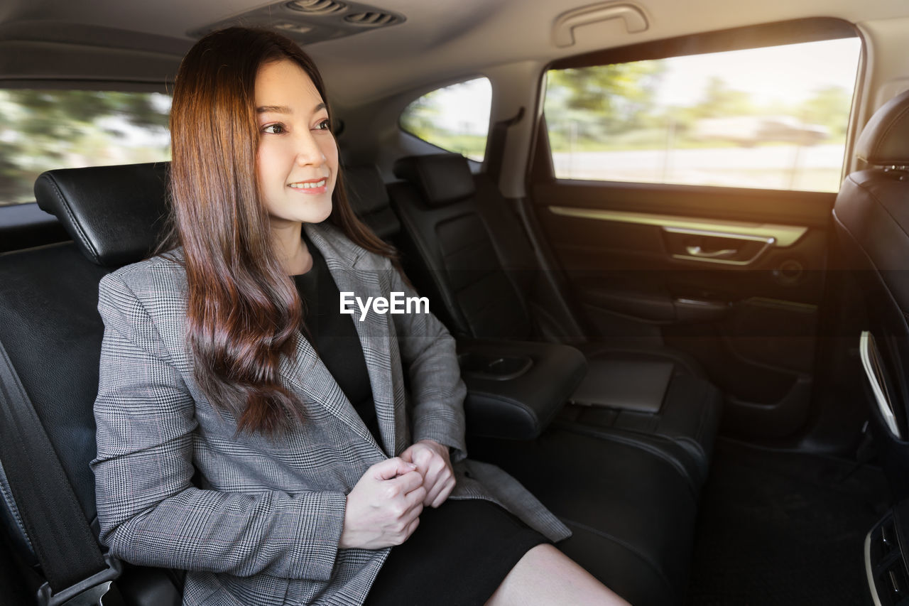 midsection of young woman sitting in car