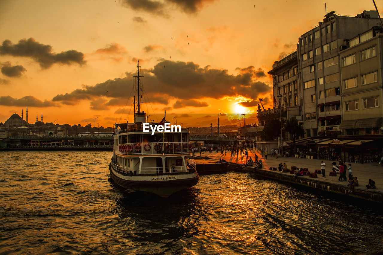 BOATS IN SEA AT SUNSET