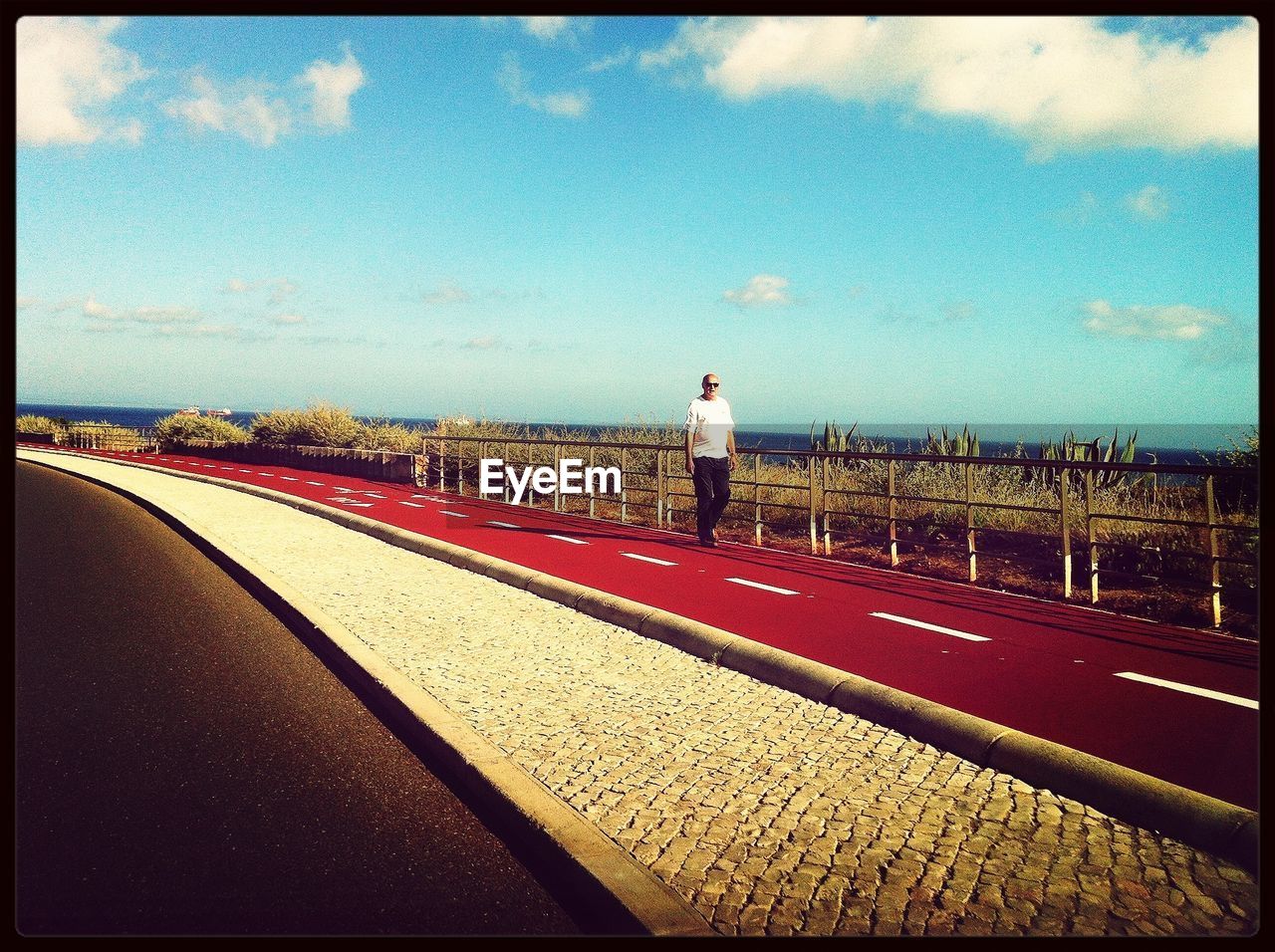 VIEW OF ROAD AGAINST CLOUDY SKY