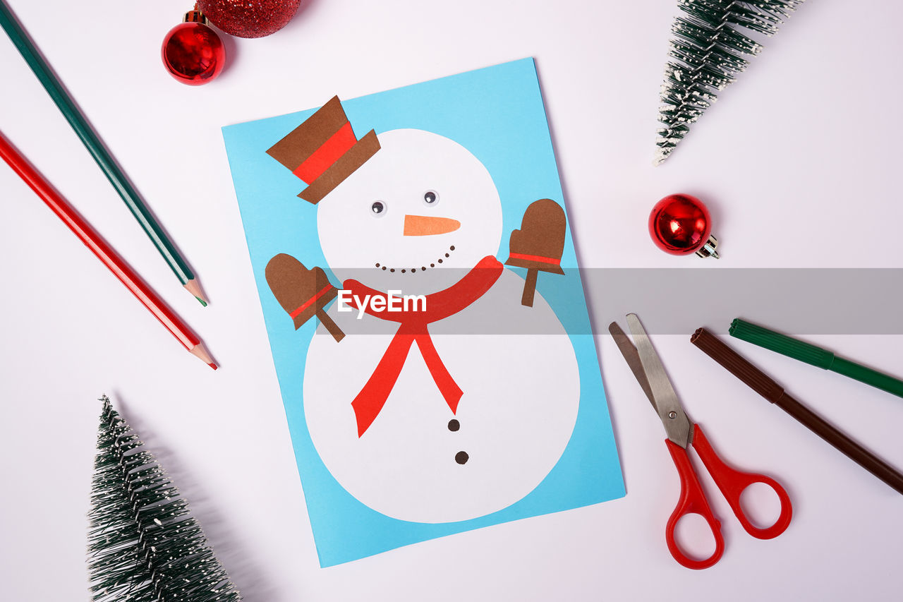 Diy christmas card with snowman from colored paper on white background
