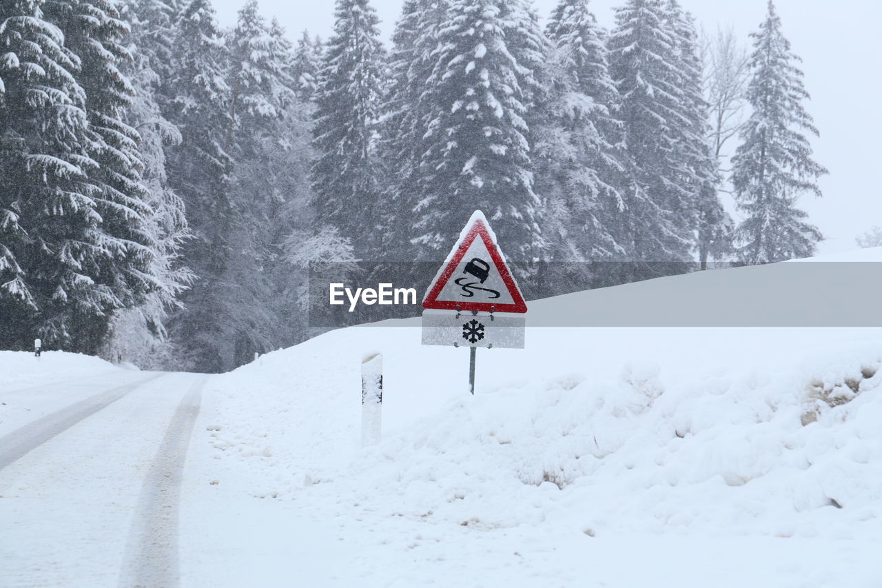 Road sign on snow covered land