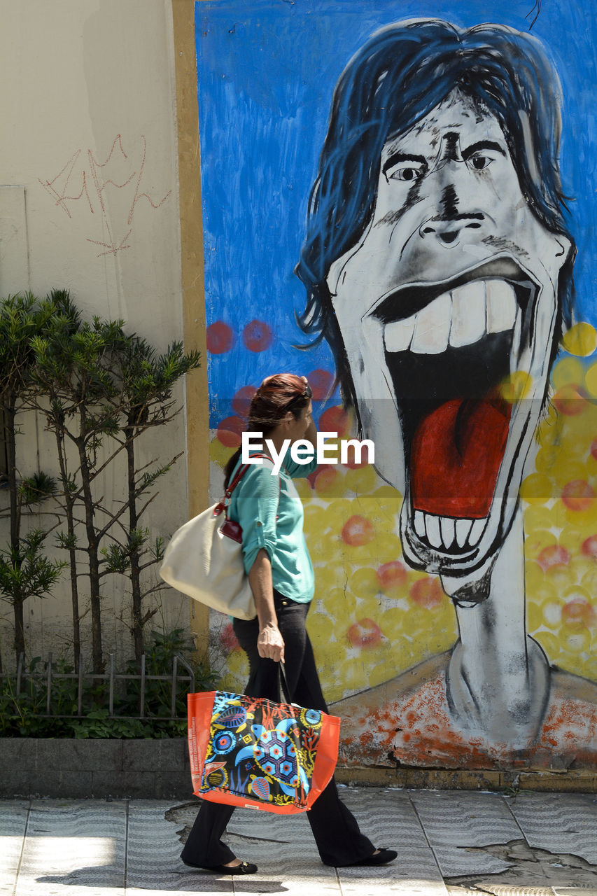 WOMAN STANDING BY WALL