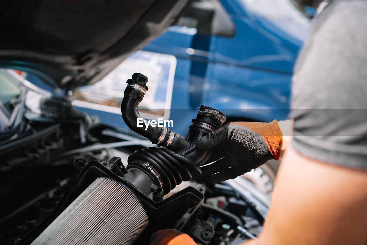 Close-up of man repairing a car with spare parts