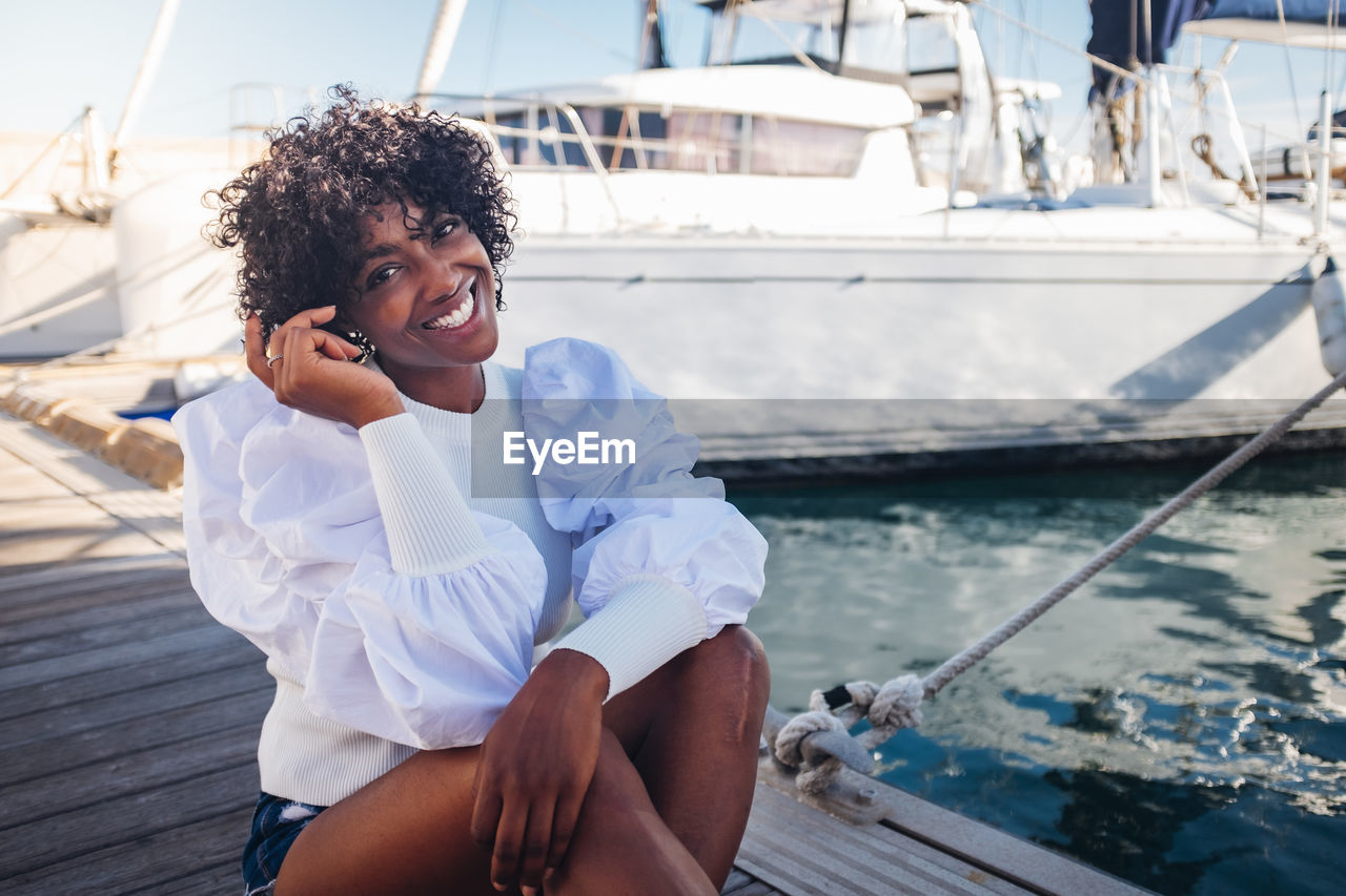 Smiling young woman using mobile phone in sea