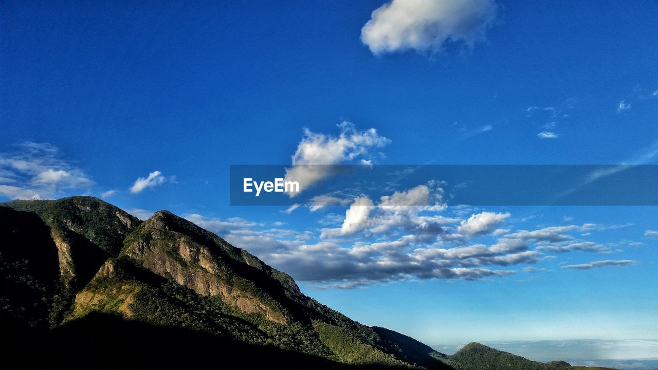 Low angle view of mountain range against cloudy sky