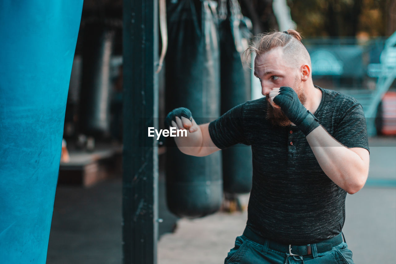 Young man practicing boxing while standing outdoors