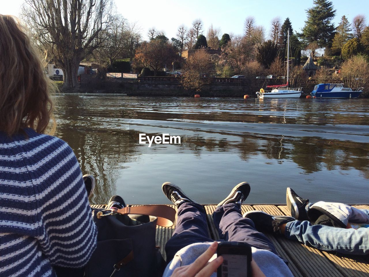 SIDE VIEW OF A MAN SITTING ON RIVERBANK