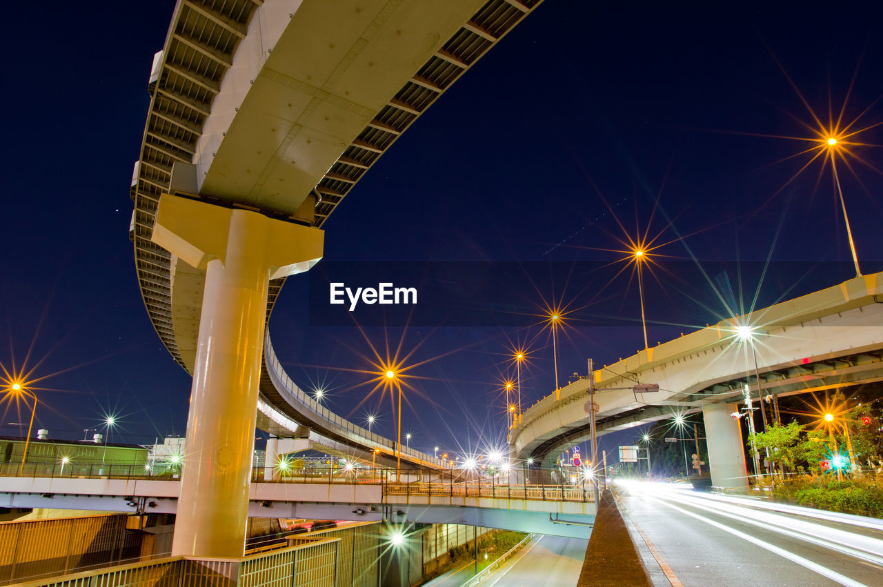 Illuminated elevated roads against sky at night