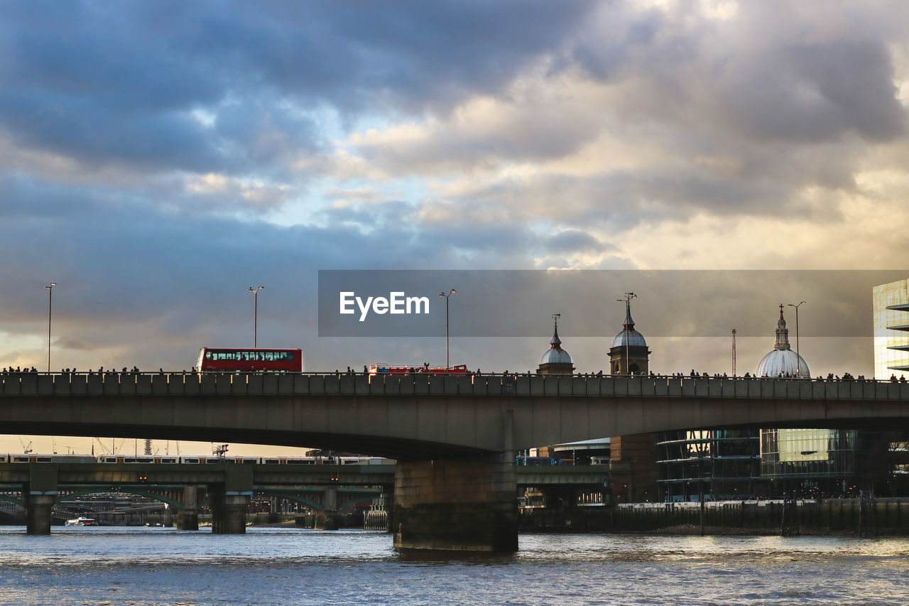 Bridge over river against cloudy sky