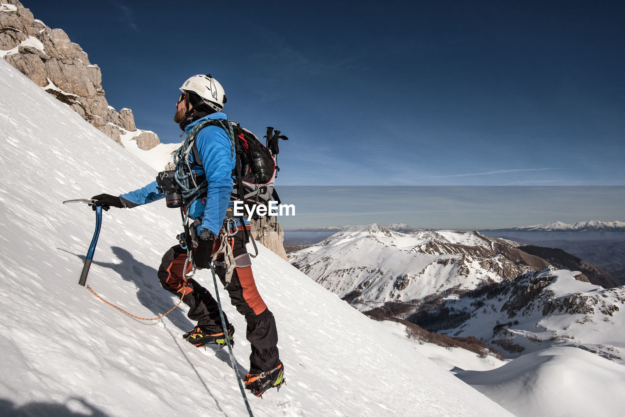 Man on snowcapped mountain against sky