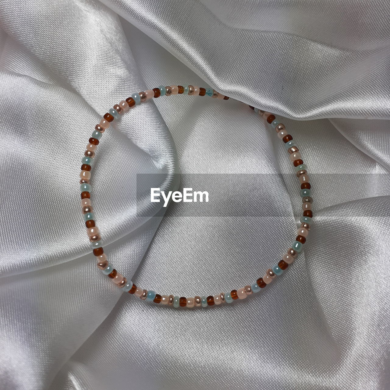 necklace, textile, luxury, wealth, chain, no people, jewelry, close-up, satin, fashion, fashion accessory, indoors, elegance, clothing, studio shot, shiny, backgrounds, full frame, brown, pattern, jewellery, silver, silk