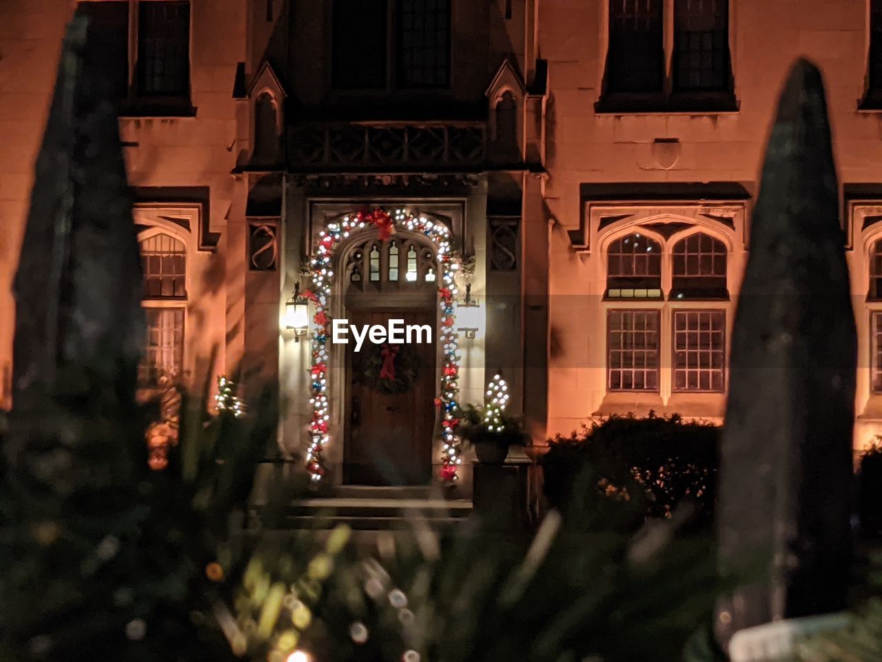 Christmas church cheer and lights at night through the iron gate.