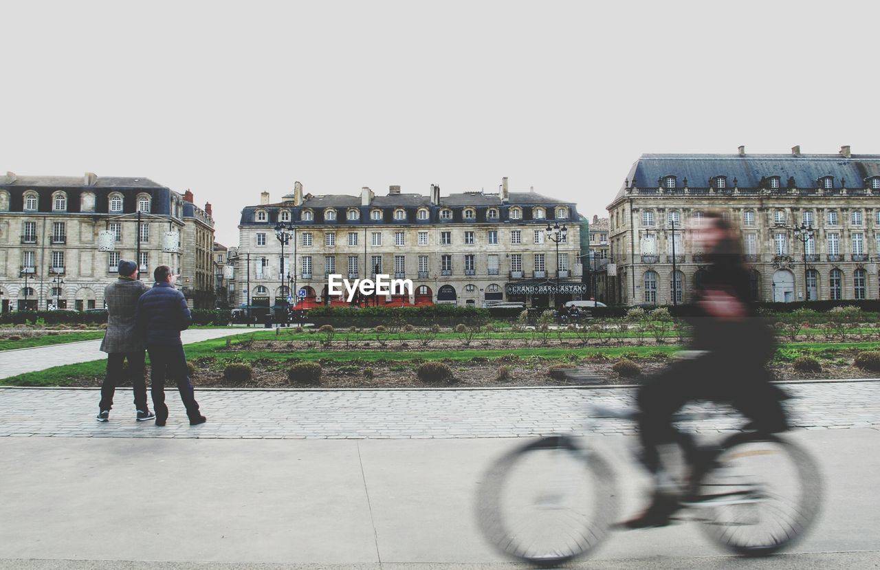 Blurred motion of man riding bicycle on city street
