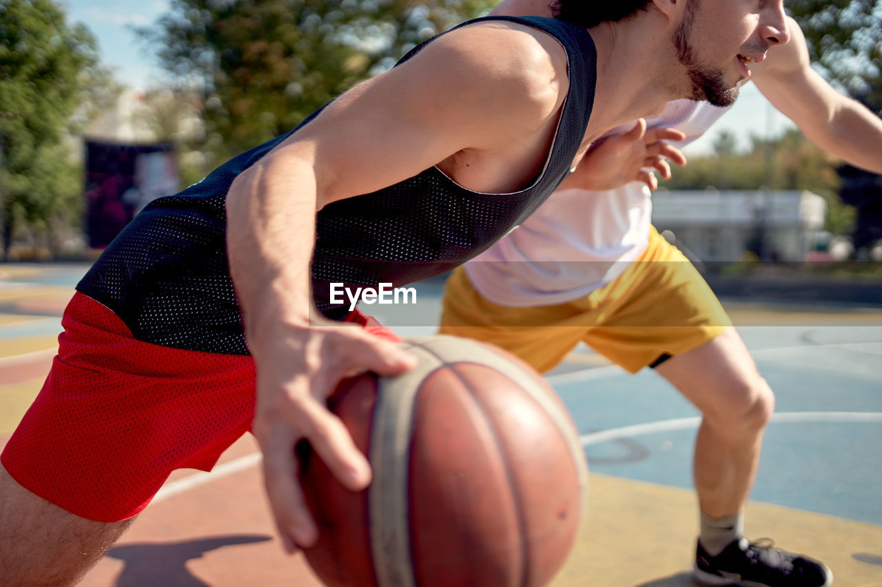 midsection of man playing basketball