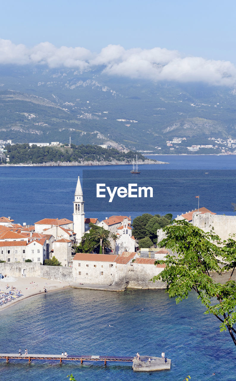 HIGH ANGLE VIEW OF TOWN BY SEA AGAINST SKY IN CITY