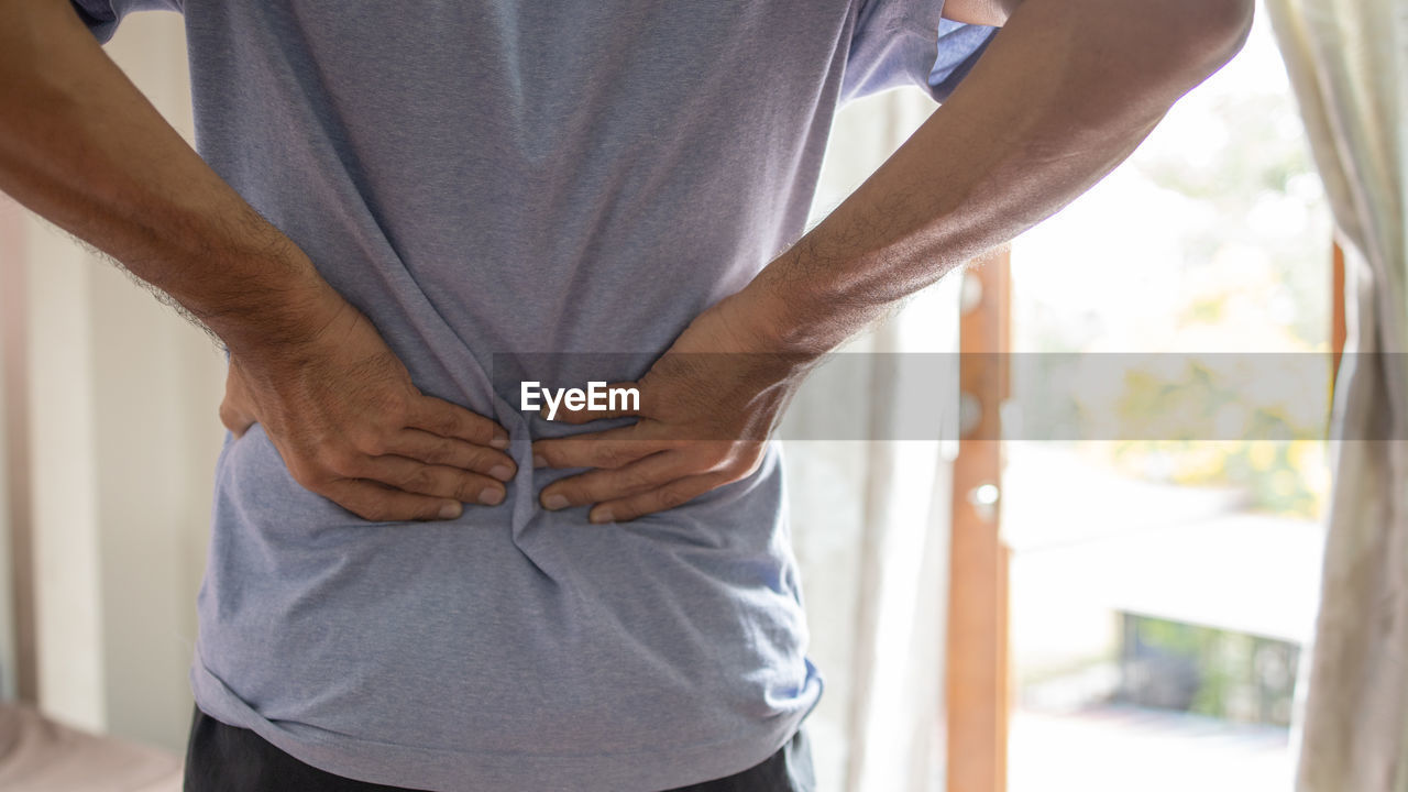 Man suffering from a have a backache, healthcare and back pain concept